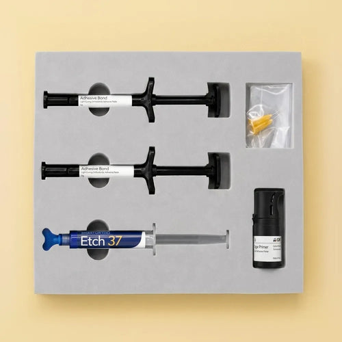 Open adhesive bonding kit tray with two adhesive syringes, Etch 37, primer, and applicator tips