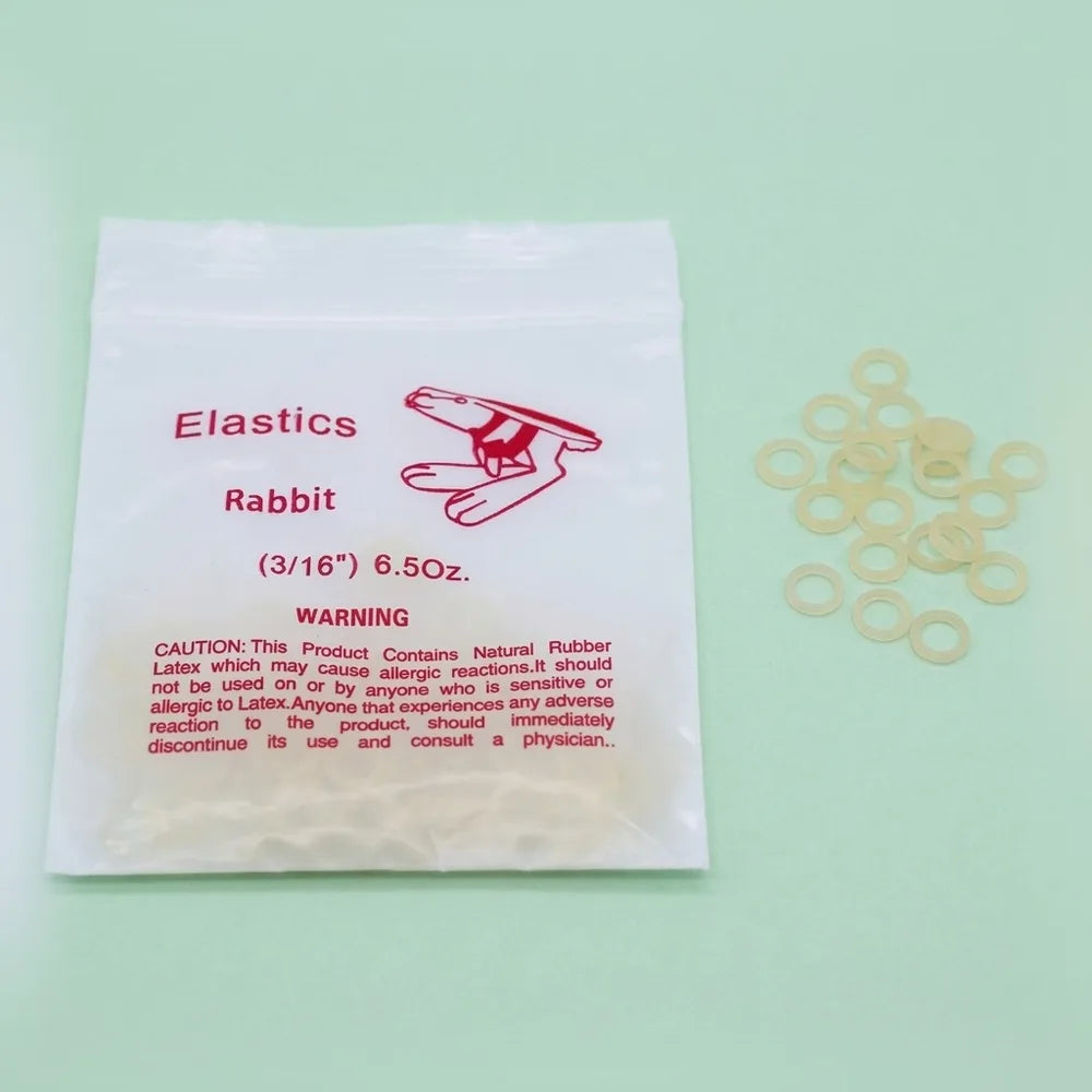Bag of latex intraoral elastics beside loose 3/16 inch rings